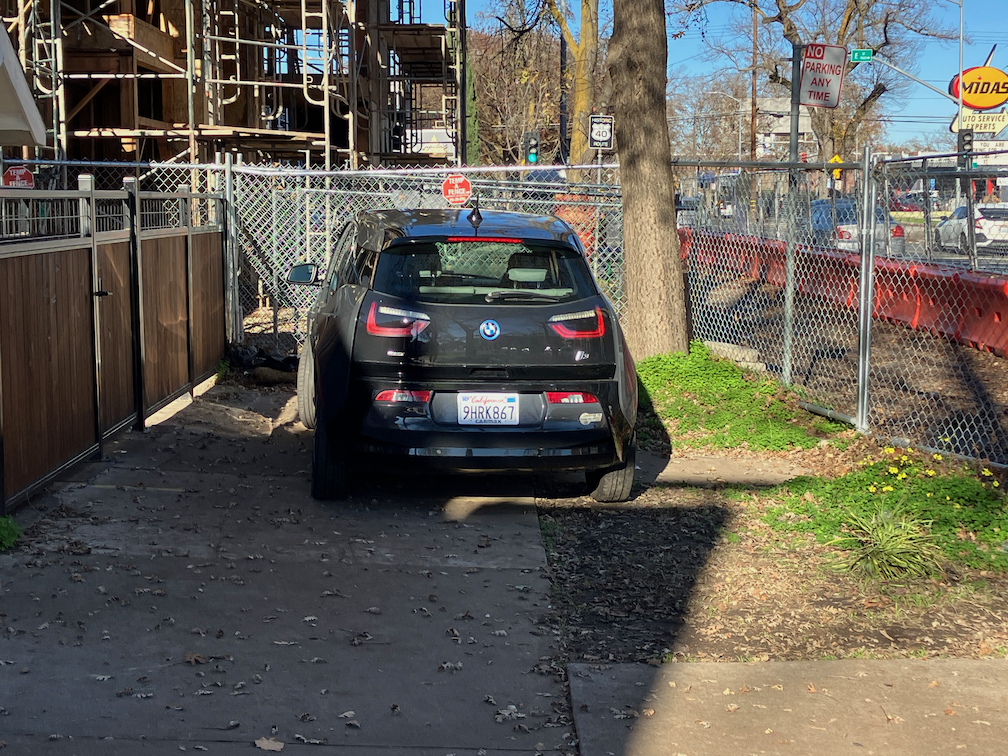 photo of 16th St sidewalk, non-detectable fence, no sign, car blocking sidewalk