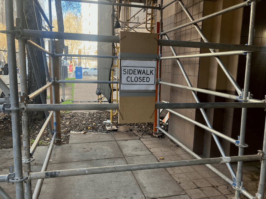 photo of SHRA construction on 6th St, scaffolding as barrier, non-compliant paper sidewalk closed sign