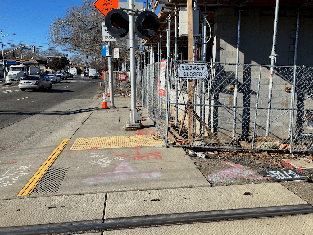 photo of confusing signing and fencing, Broadway at railroad tracks