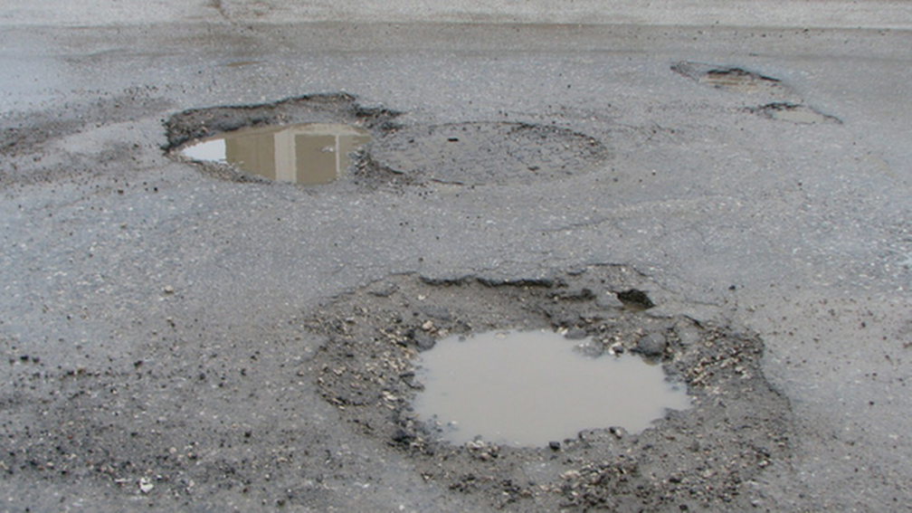photo of potholes on Sacramento County road, credit SacBee