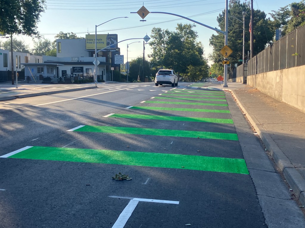 Broadway at 10th St, shared bus stop and bike lane green marking